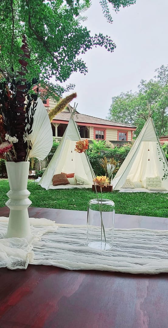 Outdoor teepees, with fluffy pillows and warm fall colors. A romantic setting by Mellow Events