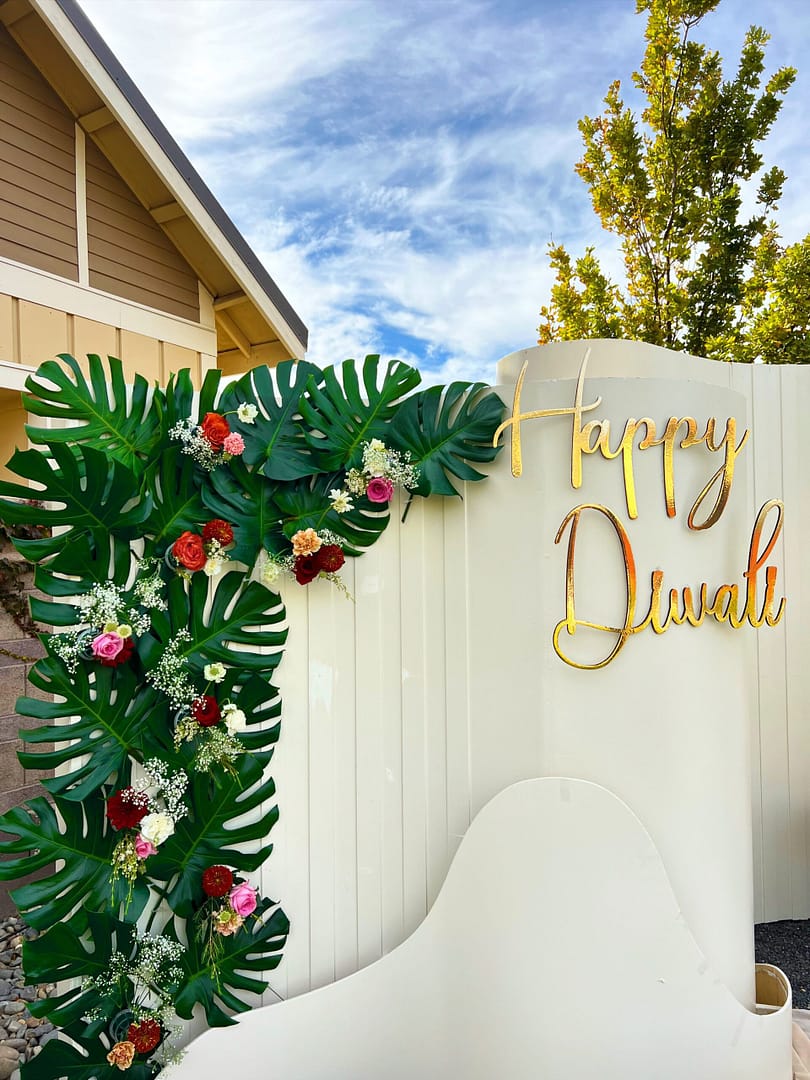 Happy Divali backdrop for event, with palm leaves and roses, by Mellow Events